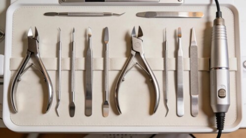 Essential nail tools including nippers, pushers, and drills arranged on a salon workbench