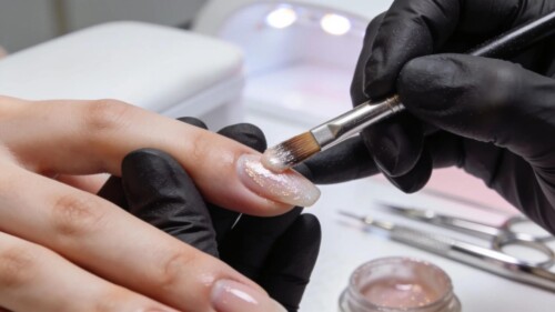 Close-up of a nail technician applying acrylic products with emphasis on technique and professional supplies